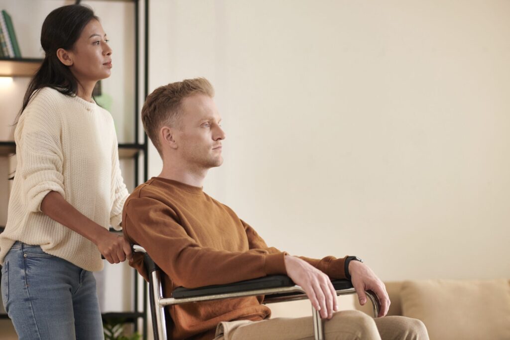 nurse carer helping their young disabled client patient in wheelchair daily support